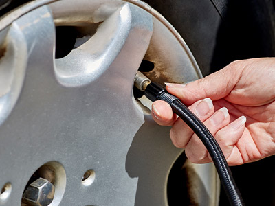 adding air to a car tire