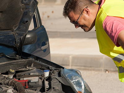 employee looking at a battery under the hood